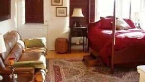 Une chambre à coucher avec un lit à baldaquin, une table de chevet en bois, une lampe et une chaise.