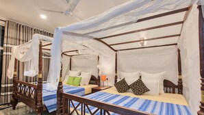 A four-poster bed with a canopy, two bedside tables, and a nightstand with a lamp. - Ashiyana (Mirissa)