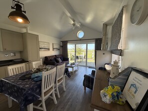 A compact kitchen with a dining area, a ceiling fan, and a view of the outdoors.