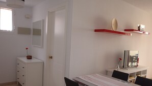 A room with a dining table, chairs, a white cabinet, a mirror, and a TV on a stand. - Spacious, large terrace, sunny, WiFi, from the sea, 250 m. from the beach (Morro Jable)