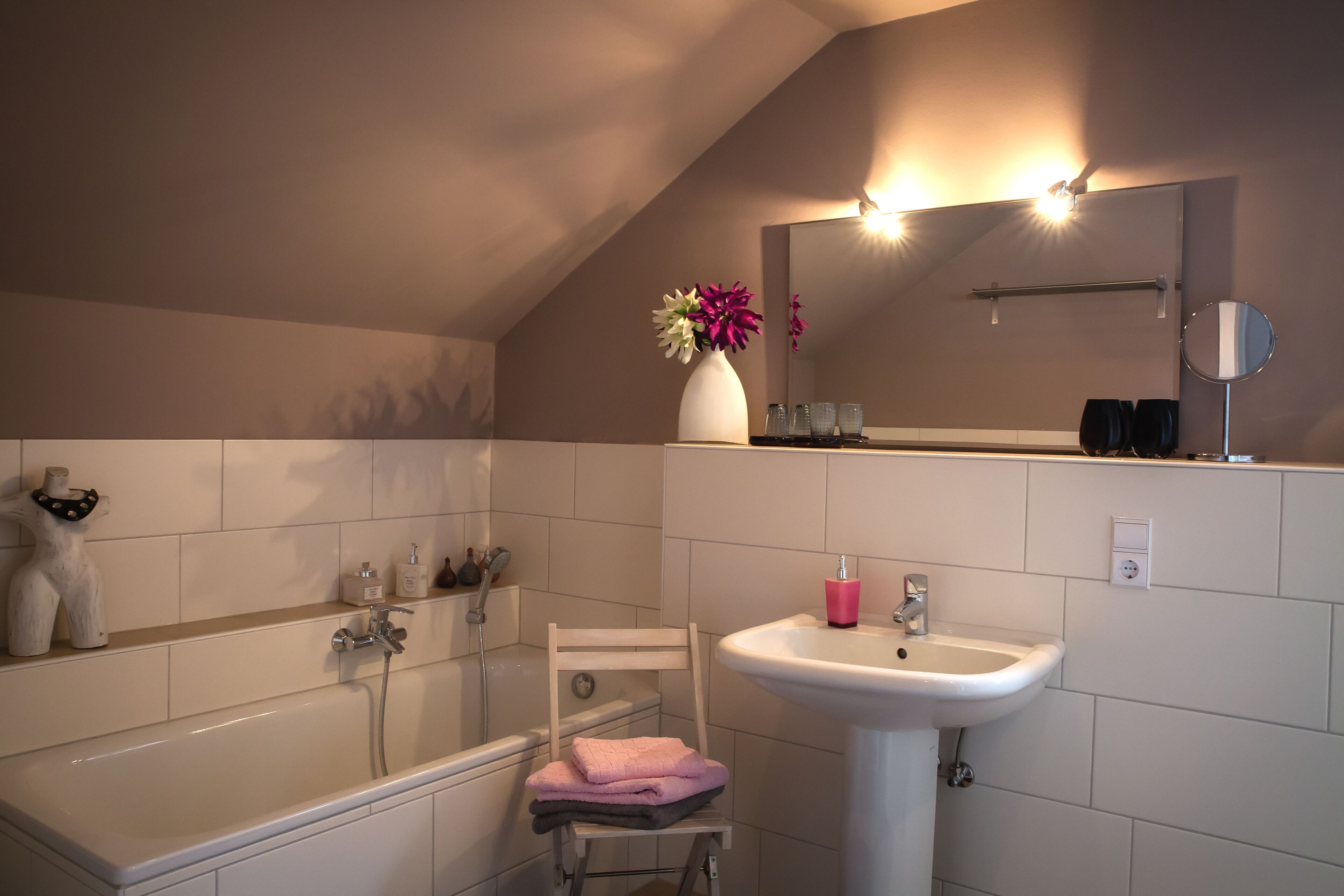 A bathroom with a bathtub, a sink, and a mirror.