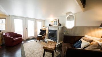 Télévision, cheminée, lecteur de DVD, livres