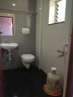 A small bathroom with a sink, toilet, and a shower.