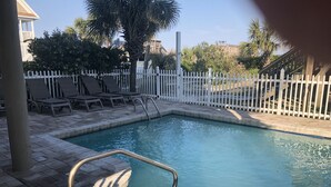 A swimming pool with a white fence, lounge chairs, and a stone deck. - EXTREME OCEANFRONT -  Heated Pool & Hot Tub / Linens & Gas grill inc. discounted (Surfside Beach)