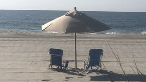 A beach with two chairs and a large umbrella. - EXTREME OCEANFRONT -  Heated Pool & Hot Tub / Linens & Gas grill inc. discounted (Surfside Beach)