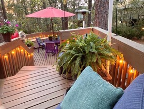 A wooden deck with a table and chairs, surrounded by potted plants and string lights. - PrvtateHomeDeerIsland,2Bdrm2Bth,FreeWifi,HrbrTwn, pet fee, permit #021437 (Hilton Head Island)