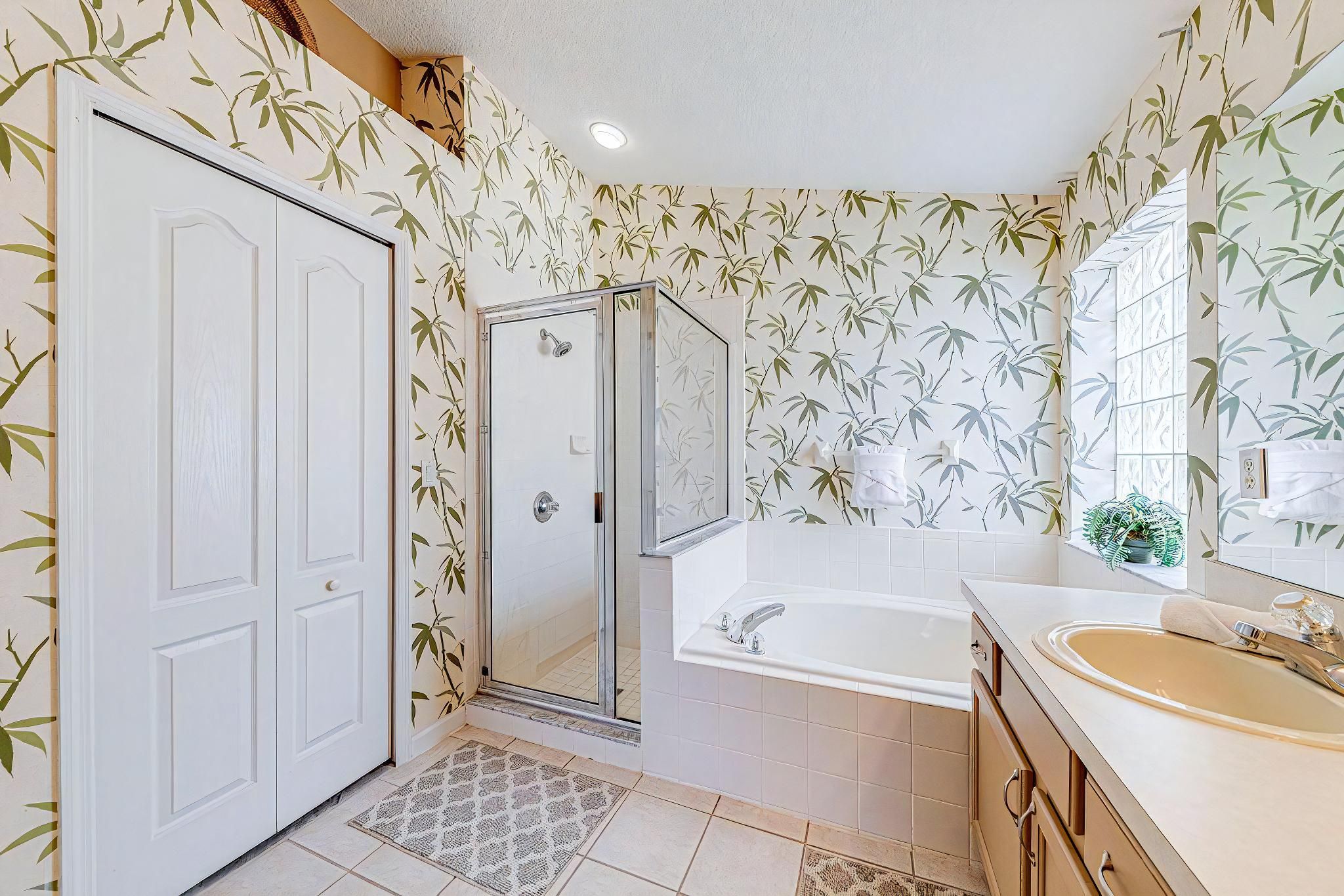 Ein Badezimmer mit Dusche, Badewanne, Waschbecken und Spiegel.