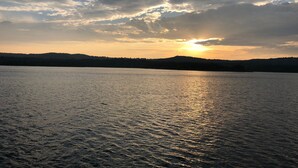 A calm lake with a sunset in the background and a silhouette of hills. - 2nd floor Poolside Studio with kitchenette. (Branson)