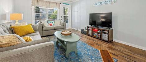 A living room with a ceiling fan, a television, a sofa, and a coffee table.