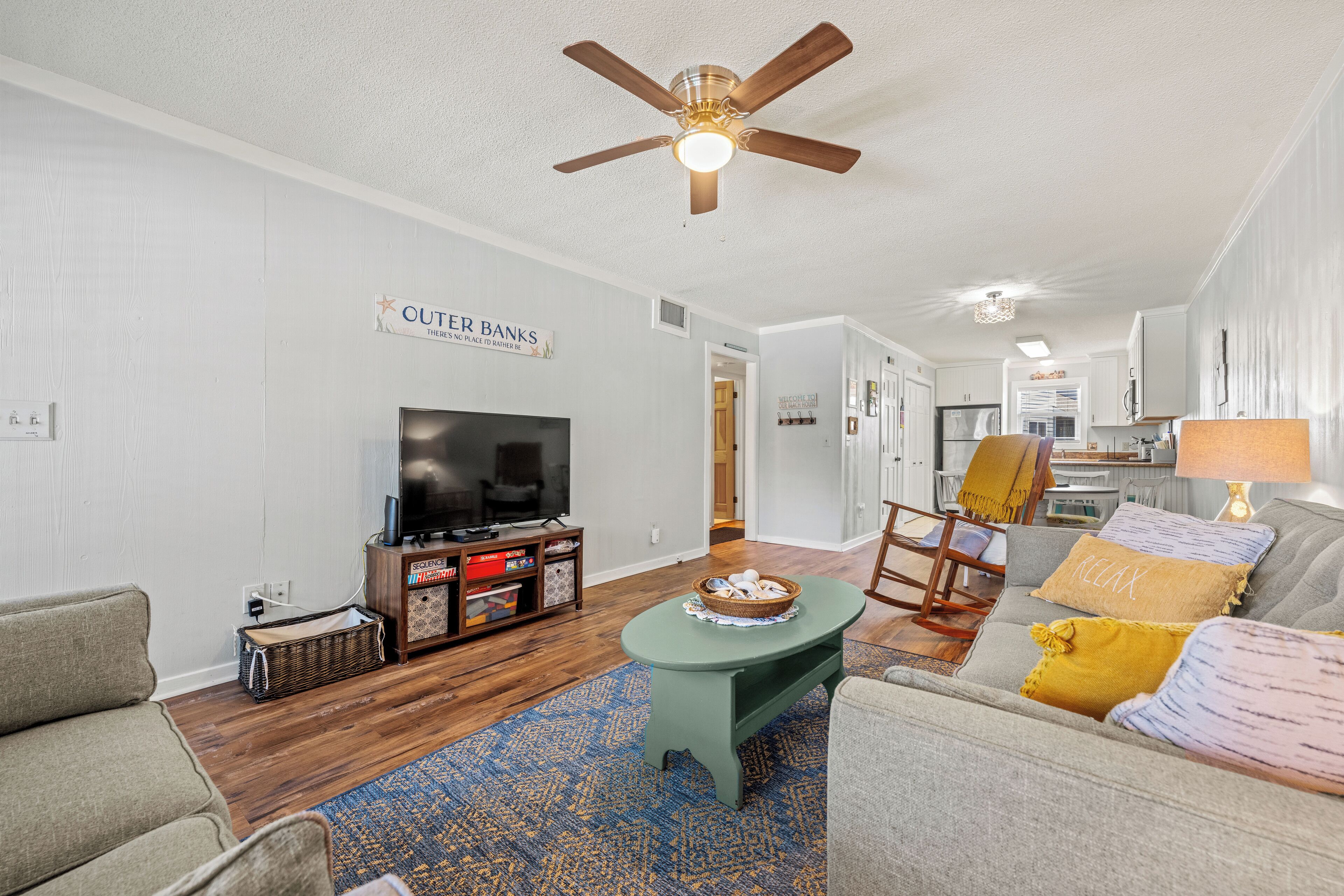 A living room with a television, a ceiling fan, and a sofa.