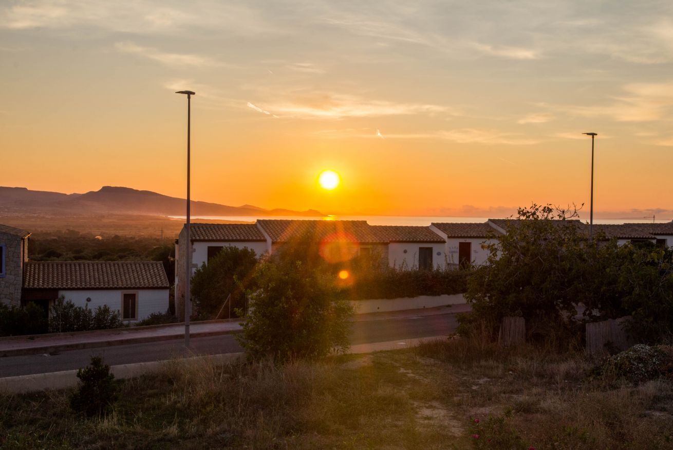 Atardecer sobre un barrio residencial con casas y una calle.