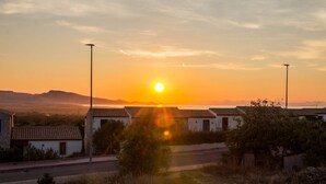 Atardecer sobre un barrio residencial con casas y una calle.