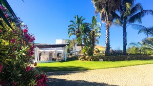 A house with a paved driveway leading to a covered patio area. - Beautiful Restored Algarve Typical Farmhouse, with Private Pool and Sea Views (Loule)