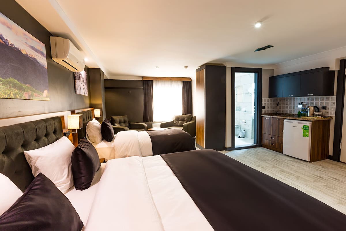 Ein Hotelzimmer mit zwei Betten, einer Küchenzeile und einem Badezimmer.