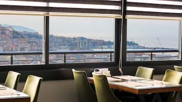 A conference room with a large window overlooking a cityscape and a body of water.