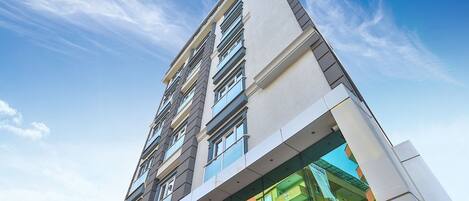 Un moderno edificio de gran altura con varios balcones y ventanas amplias.
