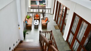 A staircase leading to a balcony with wicker furniture and a view of the street. - Rominrich (Hikkaduwa)