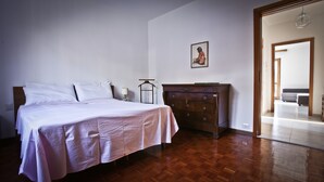 A bedroom with a bed, dresser, and a painting on the wall.