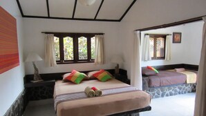 A bedroom with a large bed, a nightstand, a lamp, and a window with curtains. - Gili Hideaway (Gili Trawangan)