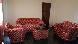 Ein Wohnzimmer mit einer Sofagarnitur, einem Couchtisch und einer Tür.