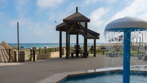 A pool area with a gazebo, a water fountain, and a view of the beach. - Wonderful Location! Clean Unit with Gorgeous Gulf Front Views! Family Friendly! (Orange Beach)