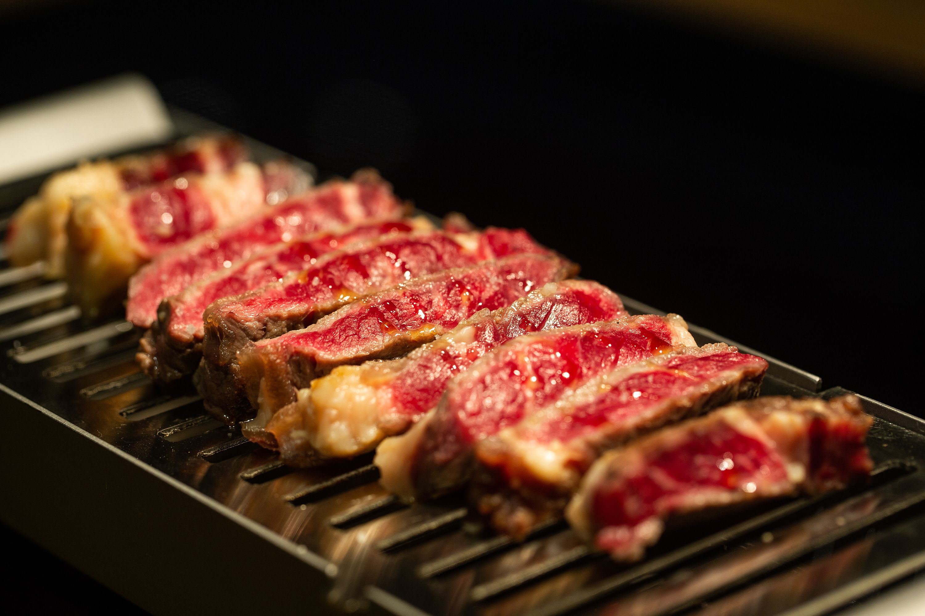 Close-up van een gegrild steak met duidelijke grillstrepen.