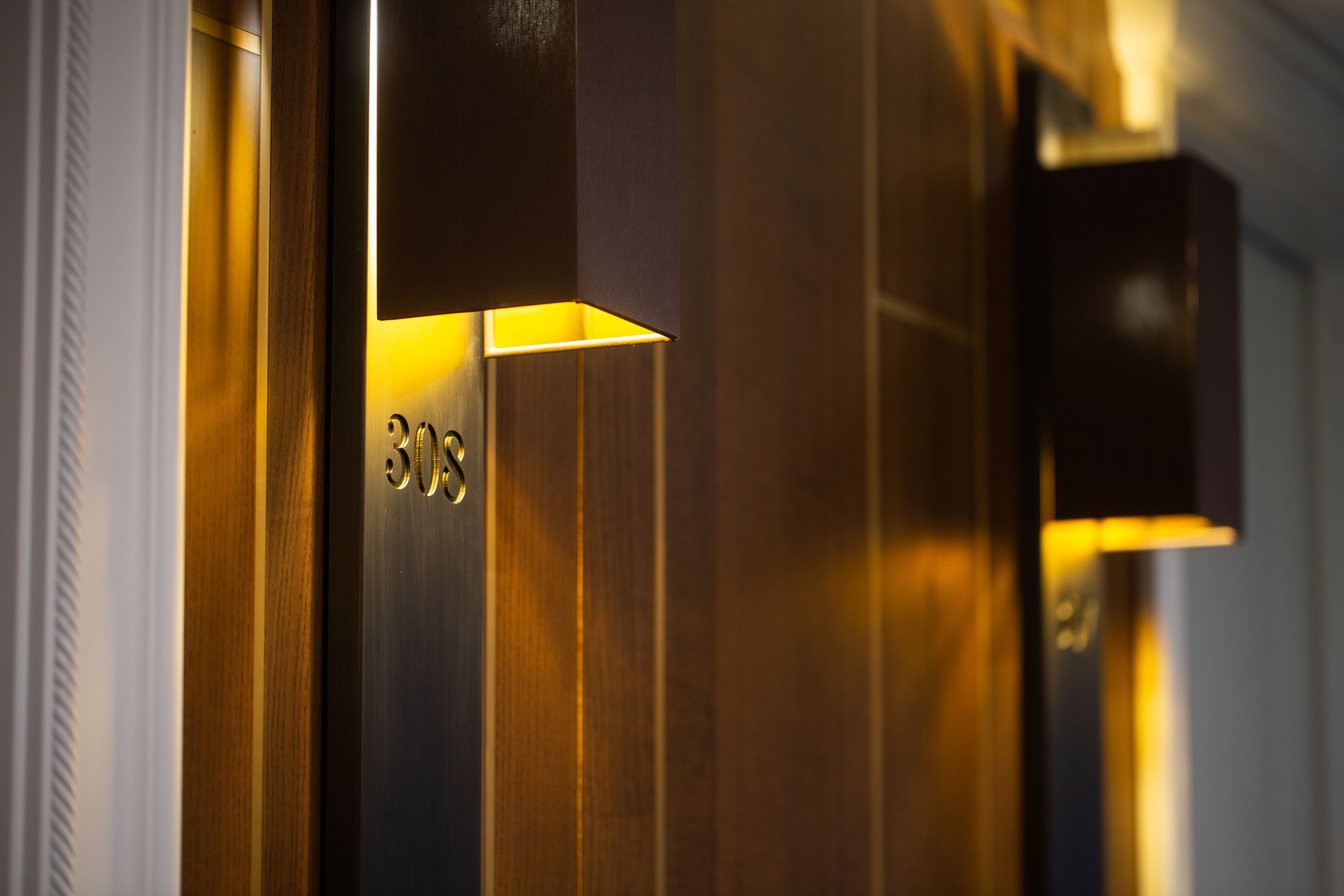 A close-up of a modern elevator interior with metallic walls and illuminated panels.