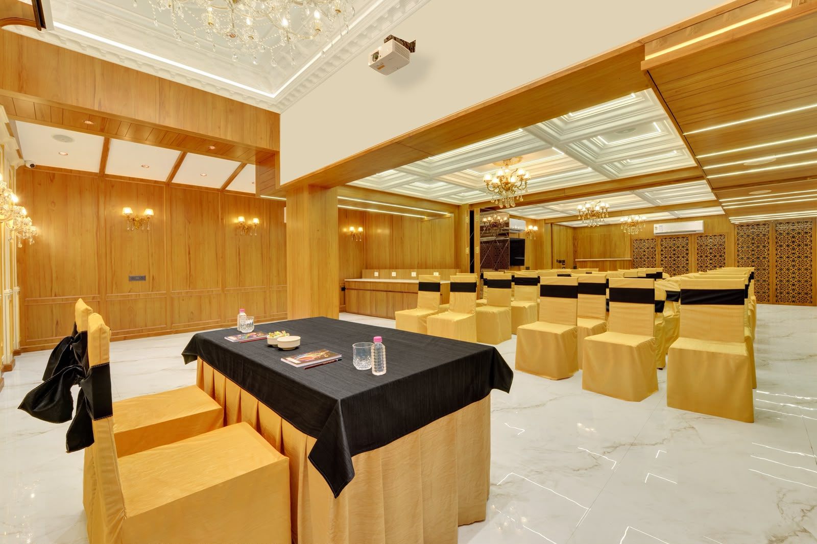 Un salón de conferencias con una larga mesa, sillas y una zona de escenario.