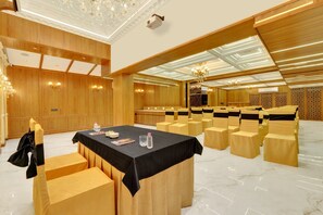 Una sala conferenze con un lungo tavolo, sedie e un'area palco.