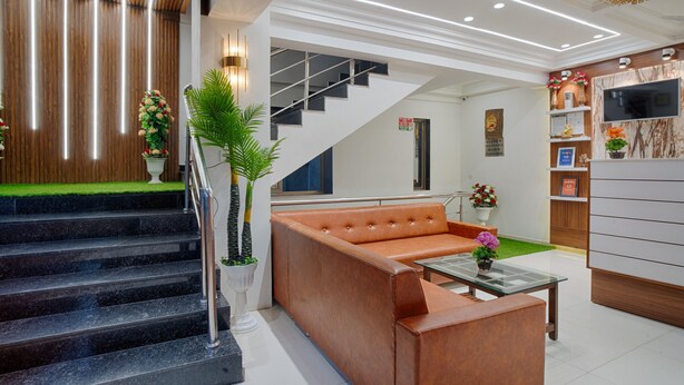 Um hall moderno com escada, sofá de couro e balcão de recepção.