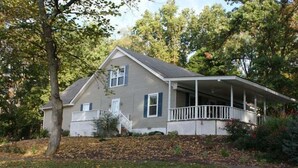 A two-story house with a covered porch and a front yard.