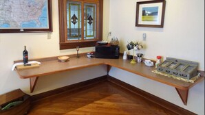 A kitchen with a wooden countertop, a sink, a stove, and a window with stained glass.