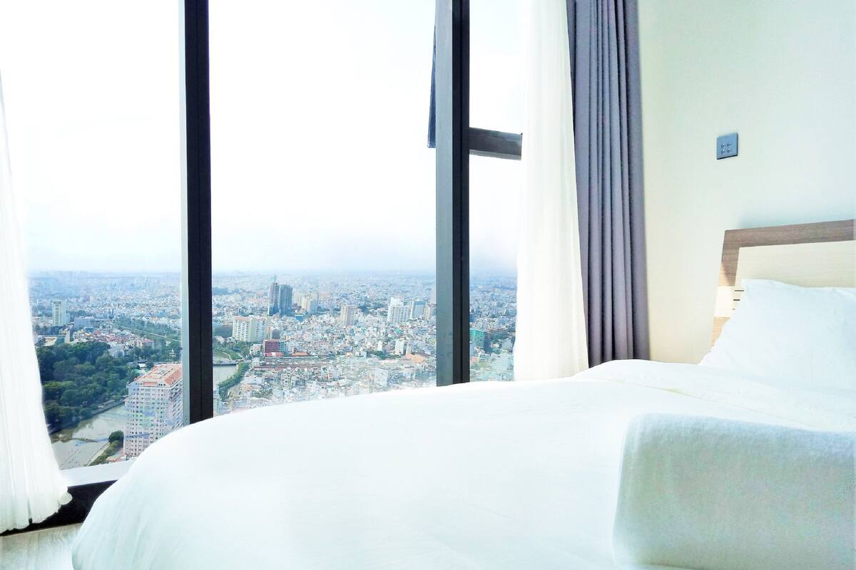Une chambre d’hôtel dotée d’une grande fenêtre donnant sur la ville.