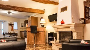 Una sala de estar acogedora con chimenea, un comedor y una cocina.