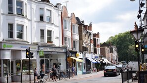A street with shops, including a bookstore and a cafe. - Magma Flat (London)
