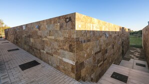 Un edificio in pietra con tetto piatto e un vialetto lastricato.