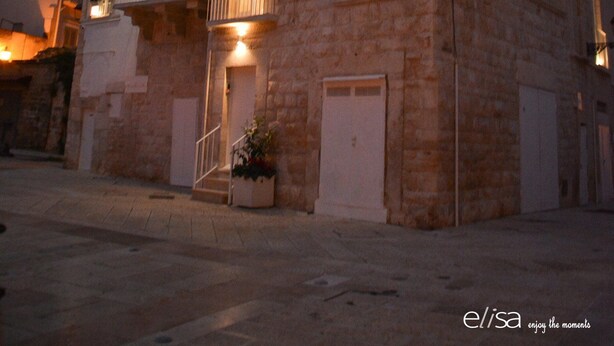 A stone building with a sign reading "L'BORGO" and balconies with potted plants. - Il Borgo B&B (Corato)