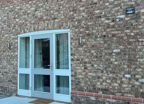 Ein Backsteinhaus mit einer weißen Tür und einem Schild, auf dem 'APPLE HOUSE NEWS' steht.