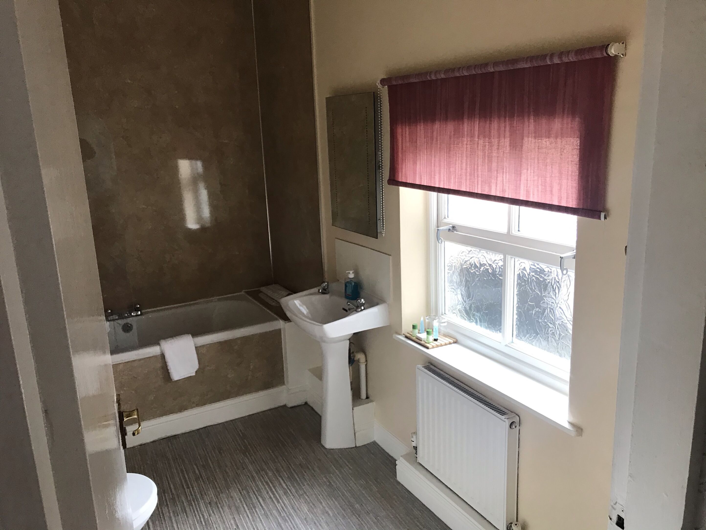 Un baño con bañera, lavamanos e inodoro.