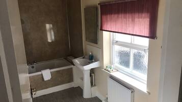 A bathroom with a bathtub, sink, and toilet.