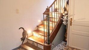 A staircase with a wooden handrail and a white door at the top. - Gîte Le Couvent    . (Cité de Carcassonne)