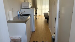 A compact hotel room with a kitchenette, a bed, a desk, and a chair. - Today's Bright and Cozy Room, Near Shibuya! (Setagaya)