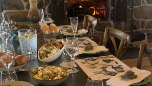 A dining table set for a meal with a stone fireplace in the background. - Fabulous Country Stay on cattle & sheep property northern NSW (Matheson)