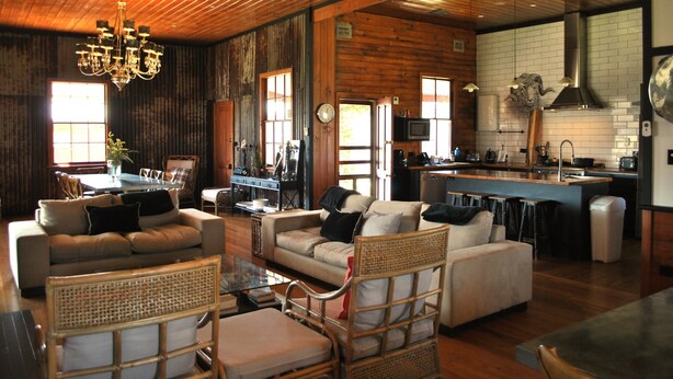 A spacious living area with a wooden ceiling, a dining table, and a kitchen area with a bar. - Fabulous Country Stay on cattle & sheep property northern NSW (Matheson)