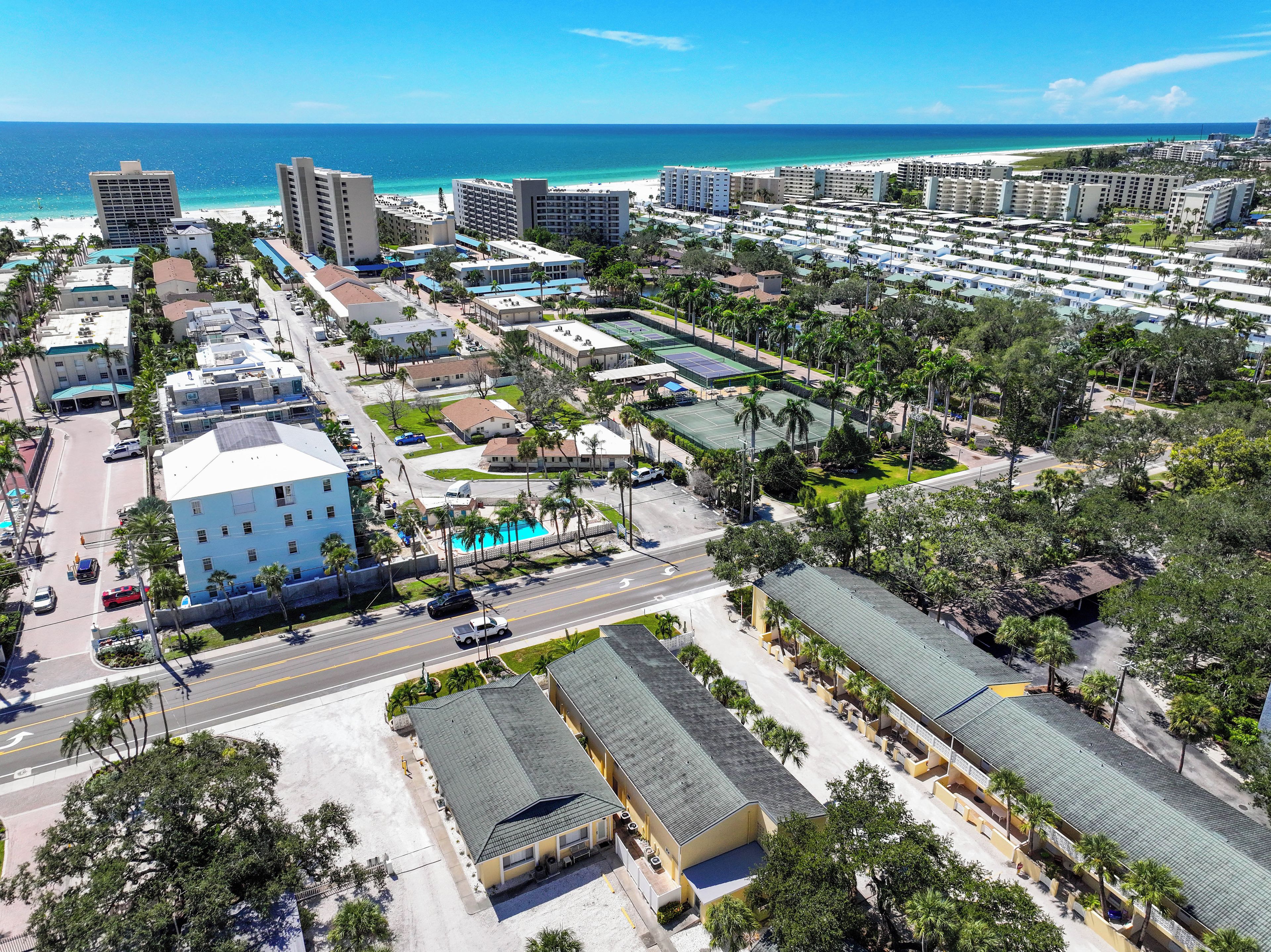 Ein Küstenresort mit mehreren Hotelgebäuden, einem Swimmingpool und einem Strand im Hintergrund.