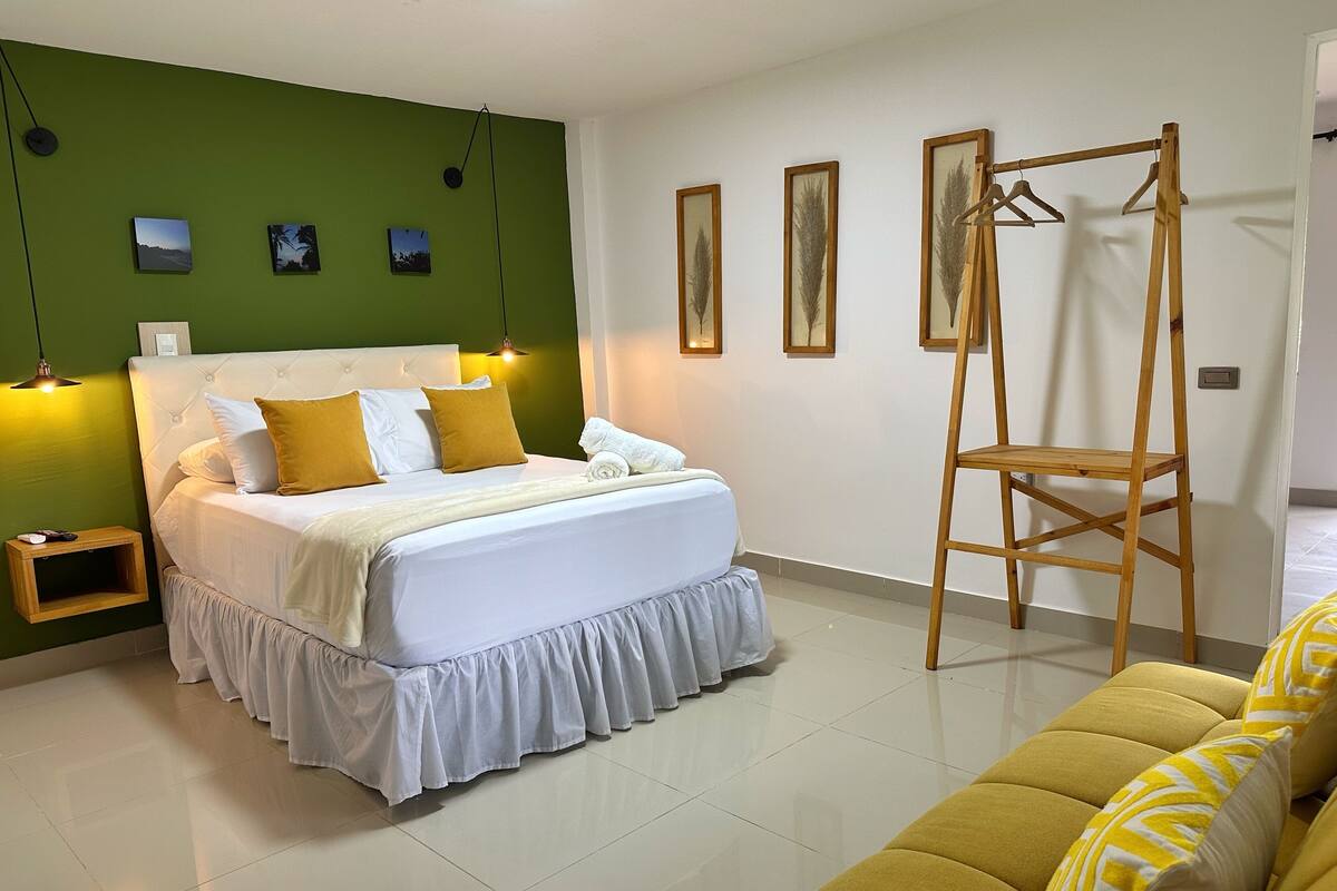 Un dormitorio ordenado con cama, mesita de noche y una escalera de madera.