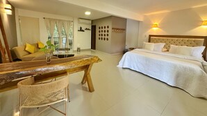 Una habitación de hotel con cama, sofá, mesa de comedor y una silla.
