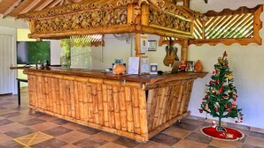 Una zona de recepción con mostrador de madera, un árbol de Navidad y una pared decorada con guitarras.