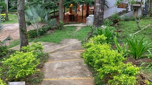 Un sendero que lleva a un edificio rodeado de vegetación exuberante y árboles.