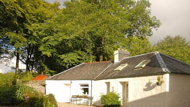 A small, white building with a sloped roof and a gravel driveway. - Hydrangea Cottage, Detached 1750,s Stone Cottage, Fully Modernised (Taynuilt)